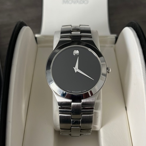 Men’s Preowned Movado quartz watch chrome finish black face. Comes in box